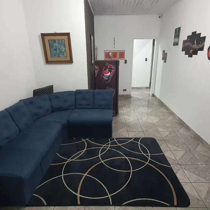Recepção com sofá, quadros e corredor para as salas