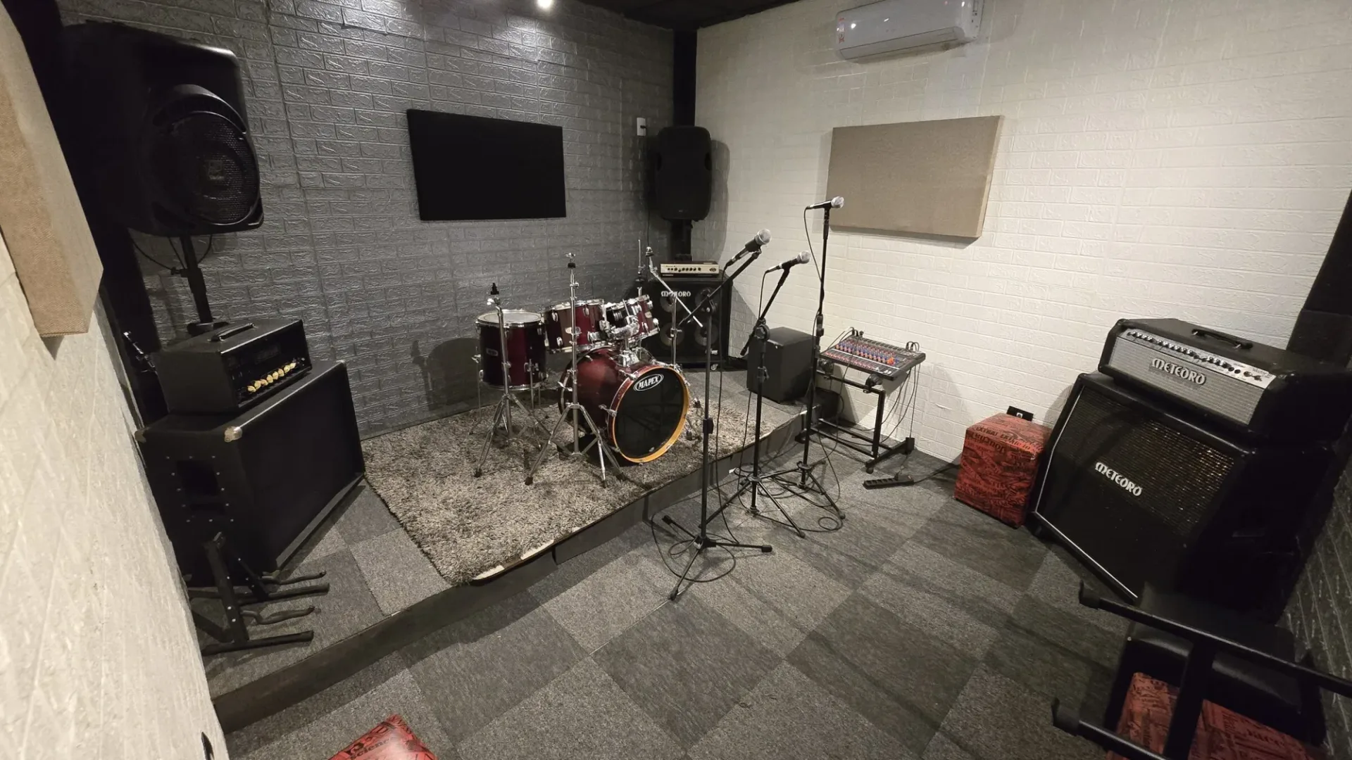 Sala 2 do Estúdio Quinta Dimensão com bateria, amplificadores e microfones prontos para a banda